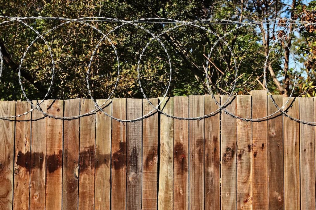 A Closeup shot on wooden fence with barbed wire