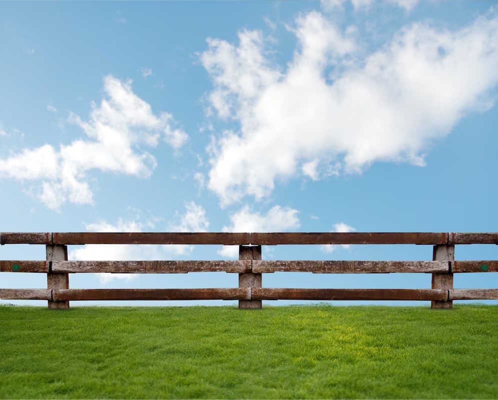 grass with clouds and a wooden fence