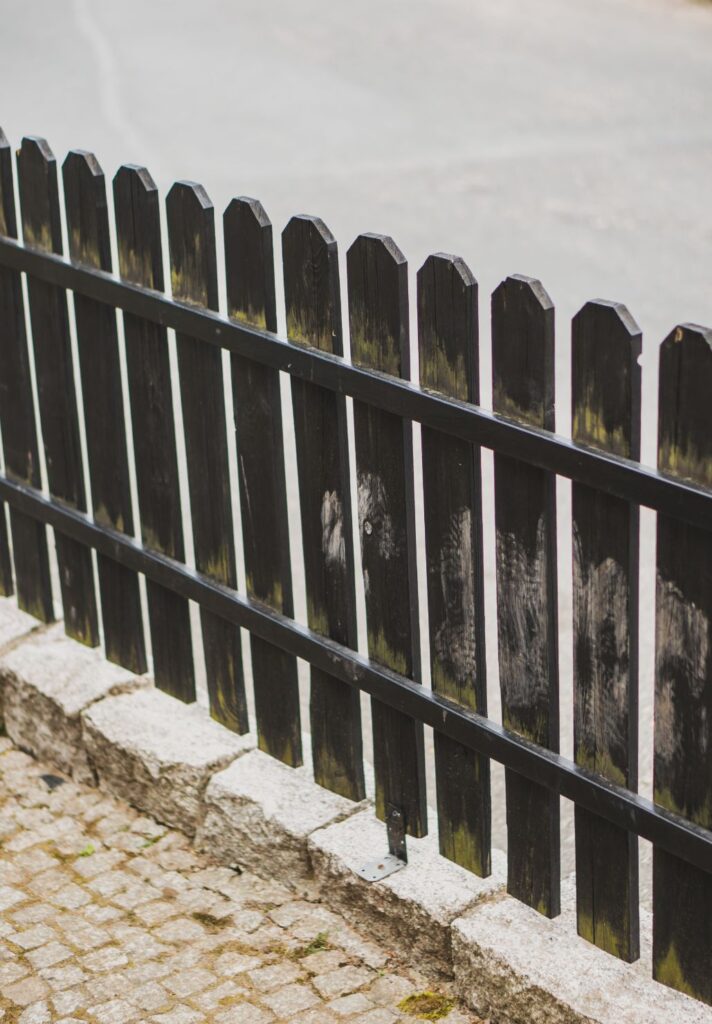 vertical shot of a wooden fence in the street